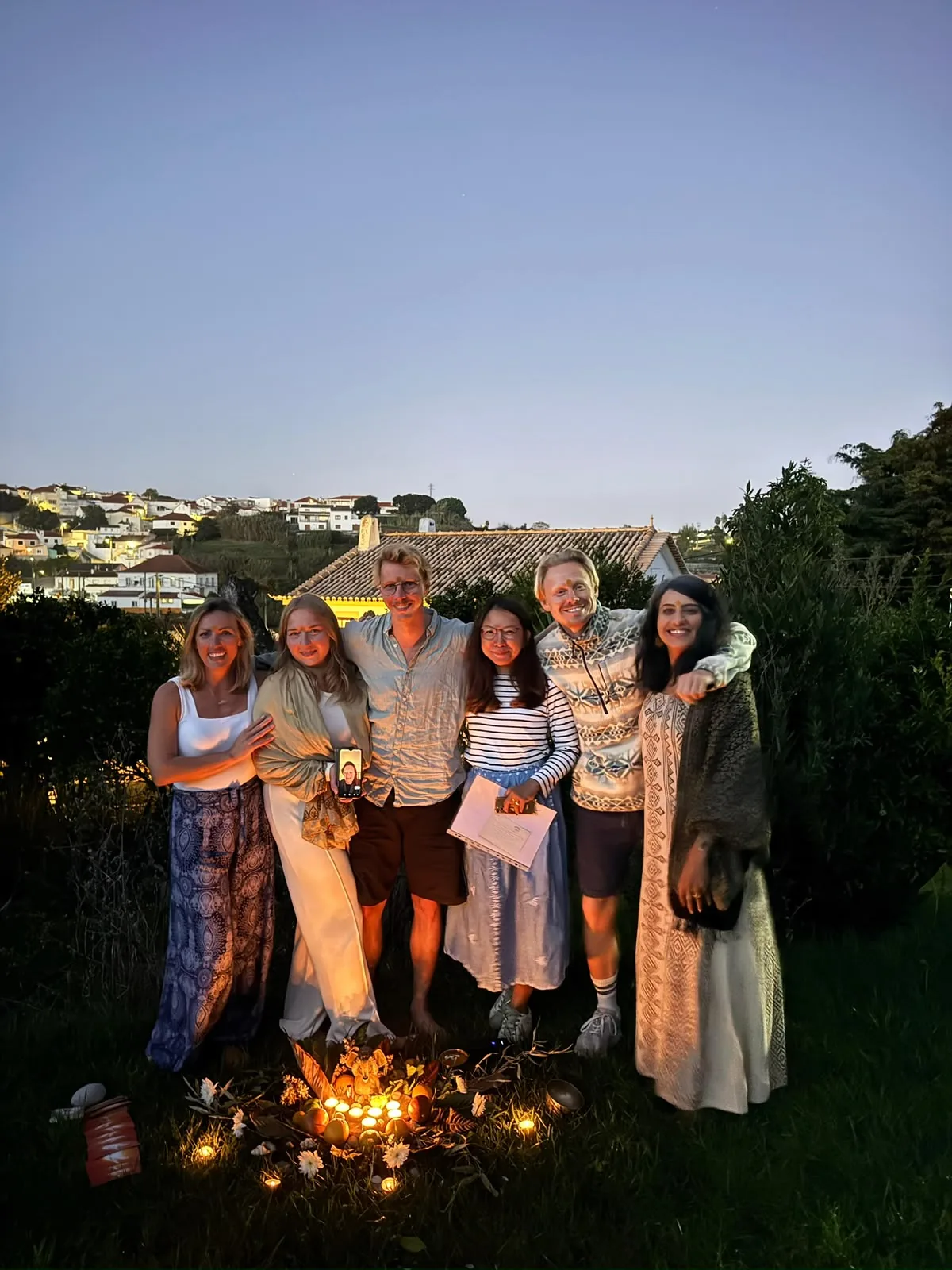 A group standing together outdoors at dusk during their time in Portugal