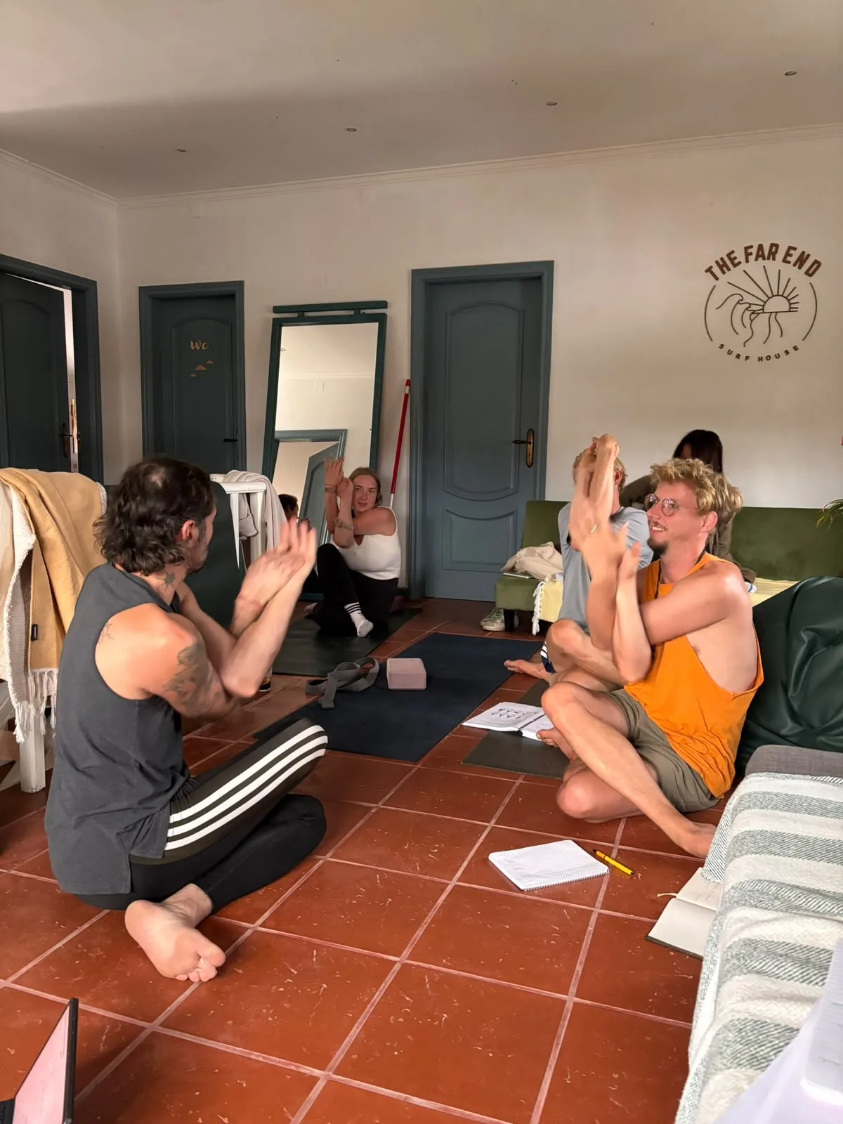 Yoga trainees sitting together with notebooks in a light-filled room in Portugal